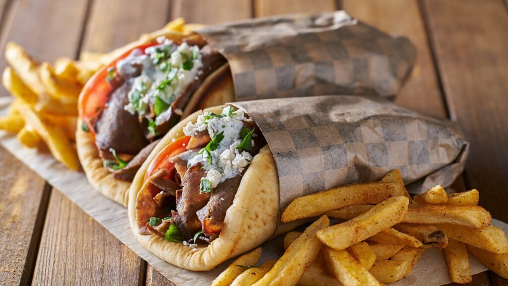  Greek Gyro that features succulent slices of marinated meat, often chicken or pork, roasted on a vertical spit.